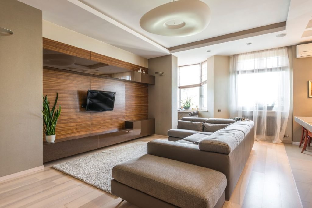 Spacious modern living room with a sleek design, featuring a TV and a comfortable sofa.